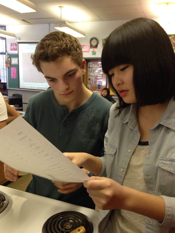 Senior Brett Lavenstein and Chinese exchange student Martina Shipley read the recipe for Lo Mein at the Feb. 26. Chinese Club meeting. 