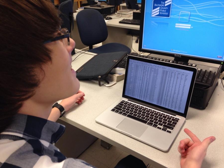 Co-founder and junior Cameron Bernhardt checks the computer’s
system processes before he presents one of his programs
to the club at a meeting last month.