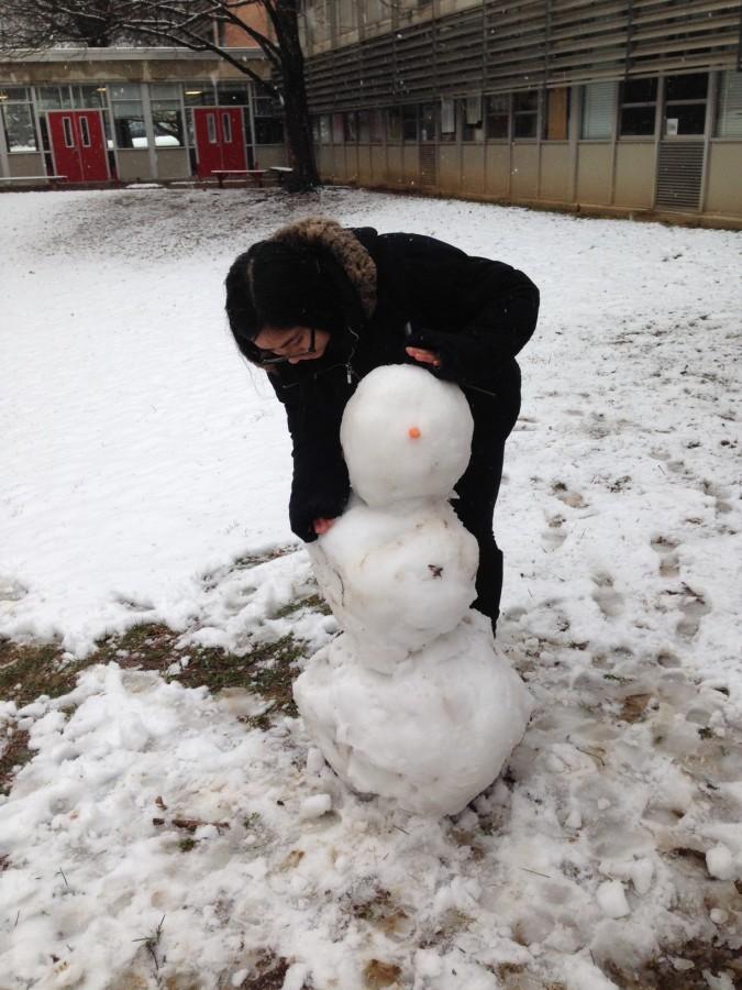 Student Chelsea Miller puts the finishing touches on her snowman March 20. Miller built the snowman to celebrate the first day of spring.