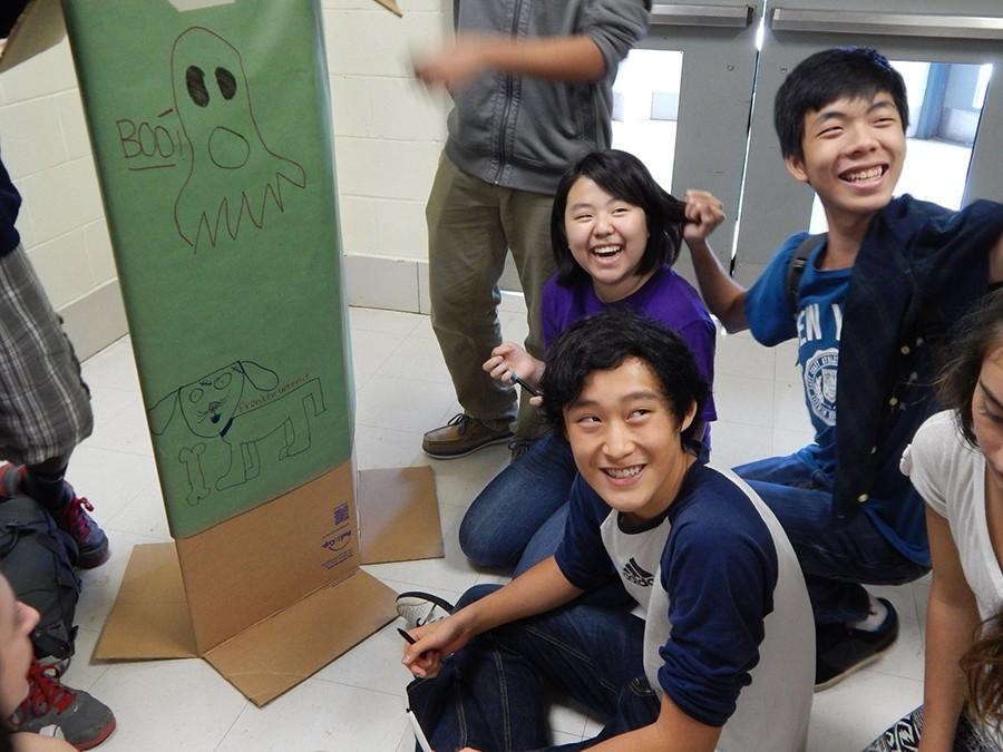 Juniors Rachel Oh and Steve Zhou, and sophomore Daniel Sun decorate Share the Treats boxes together. The effort collected hundreds of Halloween treats donated by elementary school students to give to the less fortunate. 