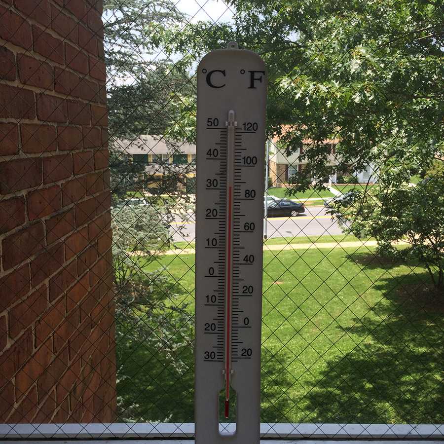 A thermometer measures the temperature of a hallway in the old building on June 12. That day, teachers reported classroom temperatures ranging from 79.5 to 90 degrees. 