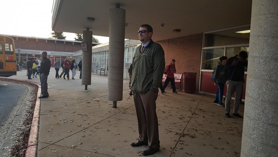 Principal Sam Wynkoop stands outside the building before school to greet students with football coach Daron Reid Oct. 20 
