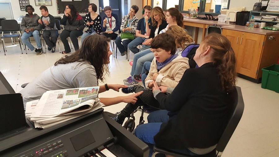Chorus teacher Christina Senita taps a steady beat on senior Katy Knittle’s leg while Knittle reflects the beat with her own movement and aide Patricia Harrison looks on. Senita praised the students in her 2A Music for Life class for their relentlessly positive attidudes.