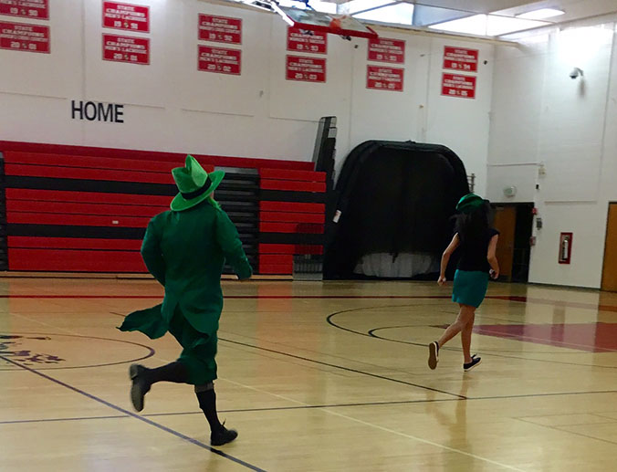 Bowman and NEHS vice president, senior Stephanie Rountree, dash across the gym to deliver the next set of limericks.