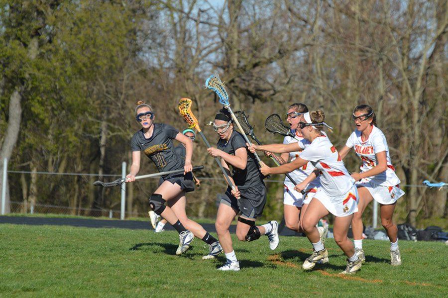 Midfielders Anna Griffin (17, a sophomore) and seniors Melanie Gandy (22) and Annie Sachs (11) flank senior Catonsville defender Lila Nazarian (17) as she takes control of the ball. 
