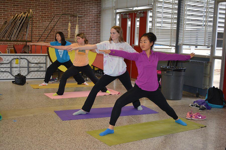 Freshmen Beulah Lee, Anna Jensen, Audrey Houghton and Lucia Qian (left to right) perform the warrior pose at the yoga club meeting April 8. 