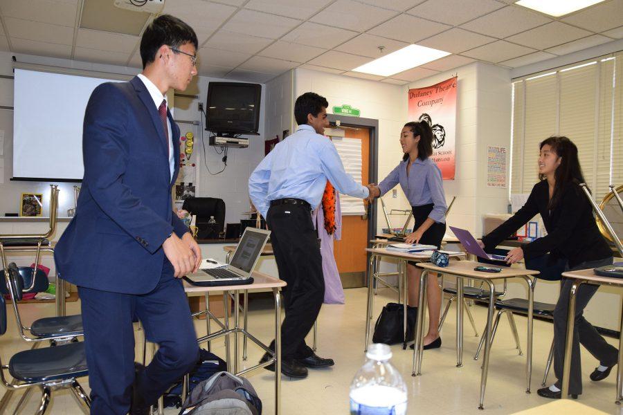 (From left to right) Students from River Hill High School shake hands with a sophomore Olivia Summons and senior Jessica Ye after the debate about the benefits and costs of the Internet of Things
