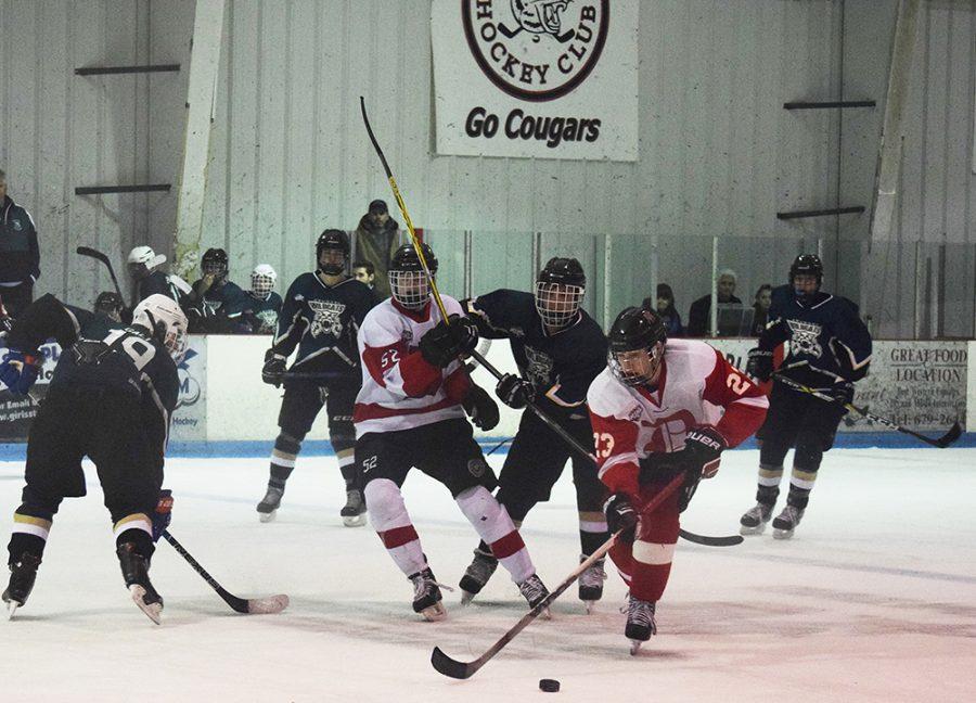 Junior Liam Snow and Jacob Pliner ward off Arundel defenders as they carry the puck into the offensive zone during a regular season game Jan. 13. The team went to win the game 5-2 and has qualified for the playoffs for the first time since the 2013-2014 season.