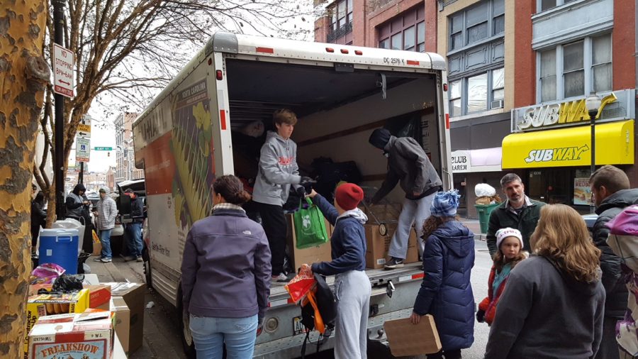 Sophomore Nick Leone, along with his family, hands out food and other neccessities to the homeless at the corner of Baltimore and Gay street Nov. 26. 